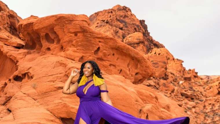 Purple gown train sweeping across red sandstone, Las Vegas flying dress photoshoot