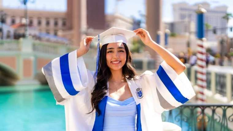 Graduate in cap and blue gown beside the Venetian canal, Las Vegas graduation photography session
